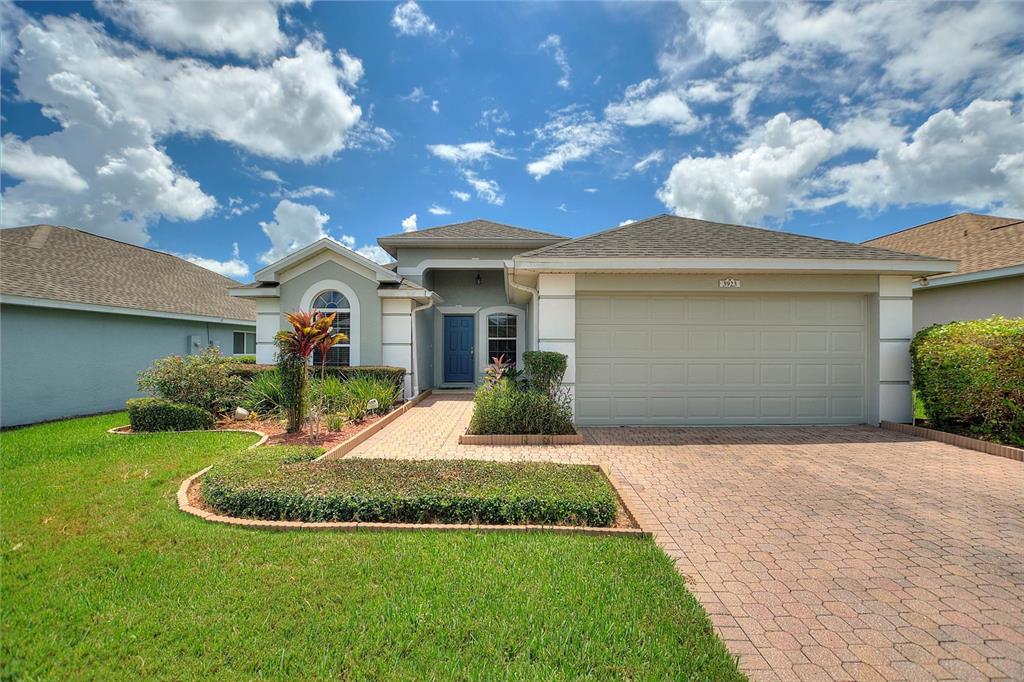 A single-story suburban house features a paver driveway, a two-car garage, and a blue front door — 3923 BALDWIN LANE, WINTER HAVEN, FL