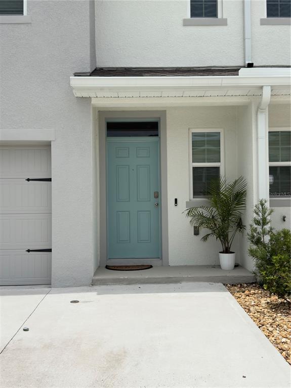 A light blue front door is centered on the exterior of a modern townhouse — 1206 BALSAM DRIVE, DAVENPORT, FL