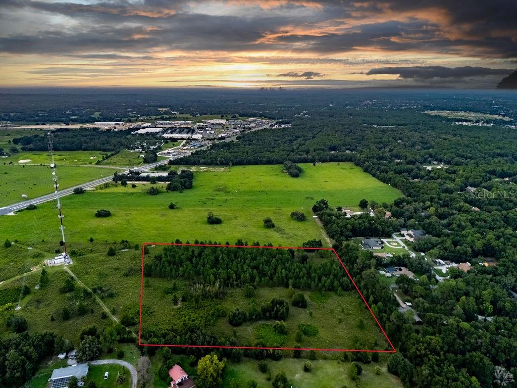 An aerial view shows a rectangular plot of land outlined in red amidst rural greenery — 1083 N OBRIEN POINT, LECANTO, FL