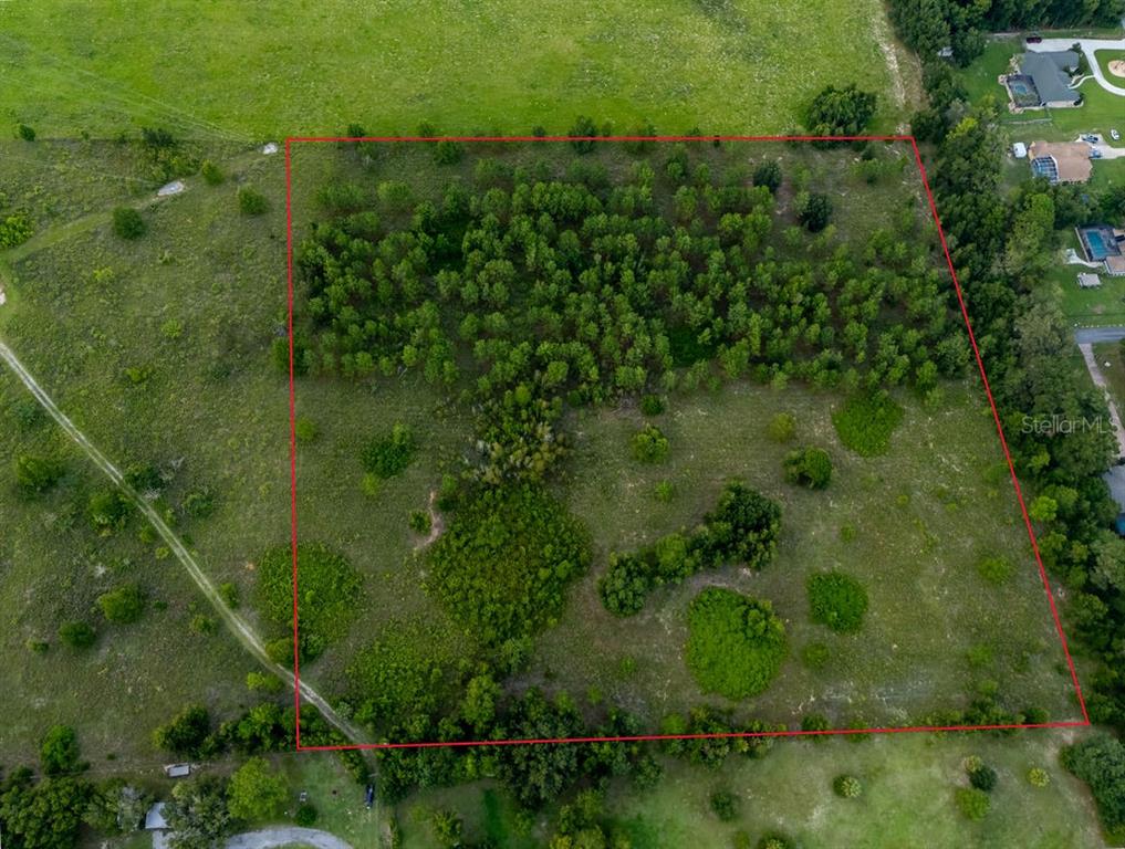 An aerial view shows a rectangular plot of land with a wooded area and grass — 1083 N OBRIEN POINT, LECANTO, FL