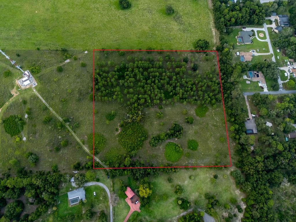 An aerial view shows a rectangular plot of land outlined in red amidst grassy fields — 1083 N OBRIEN POINT, LECANTO, FL