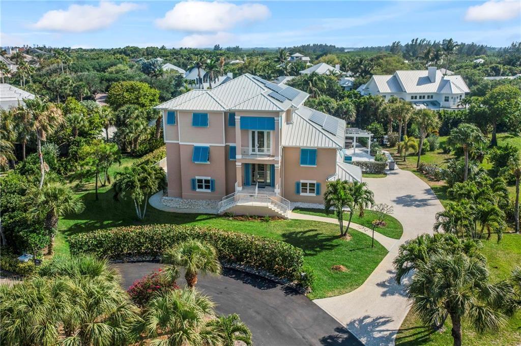 An aerial view of a three-story house with blue shutters and a metal roof — 2275 Genesea Lane, Vero Beach FL 32963, VERO BEACH, FL