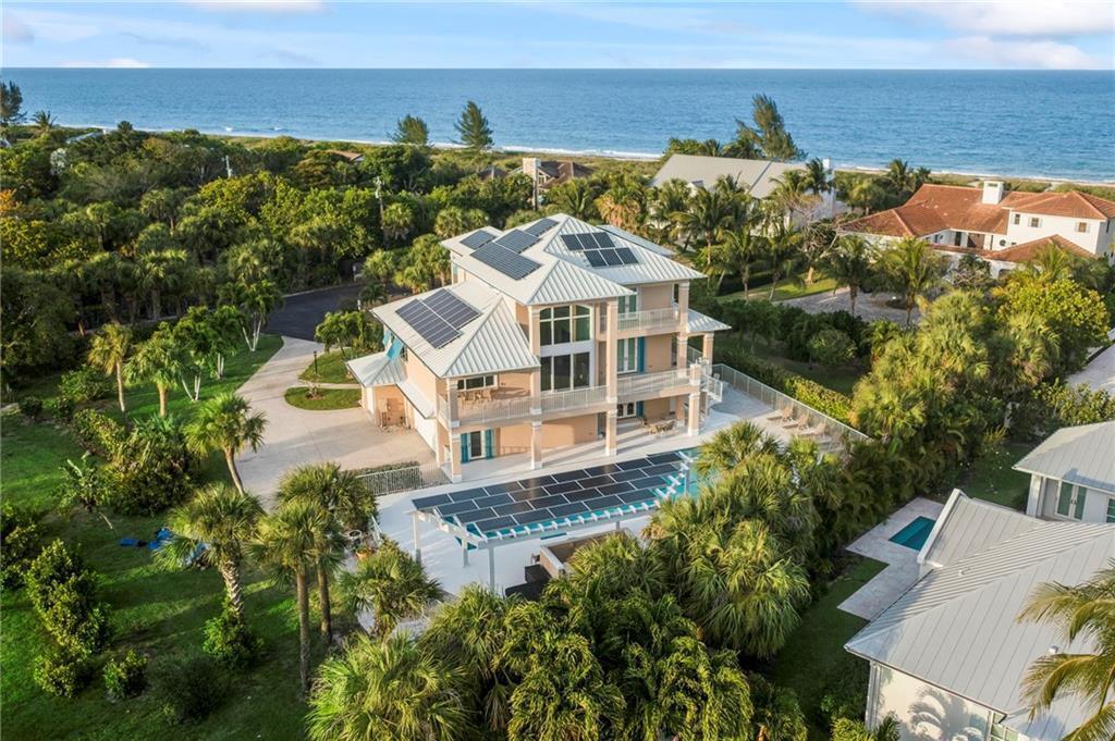 An aerial view of a multi-story coastal home with solar panels and a swimming pool — 2275 Genesea Lane, Vero Beach FL 32963, VERO BEACH, FL