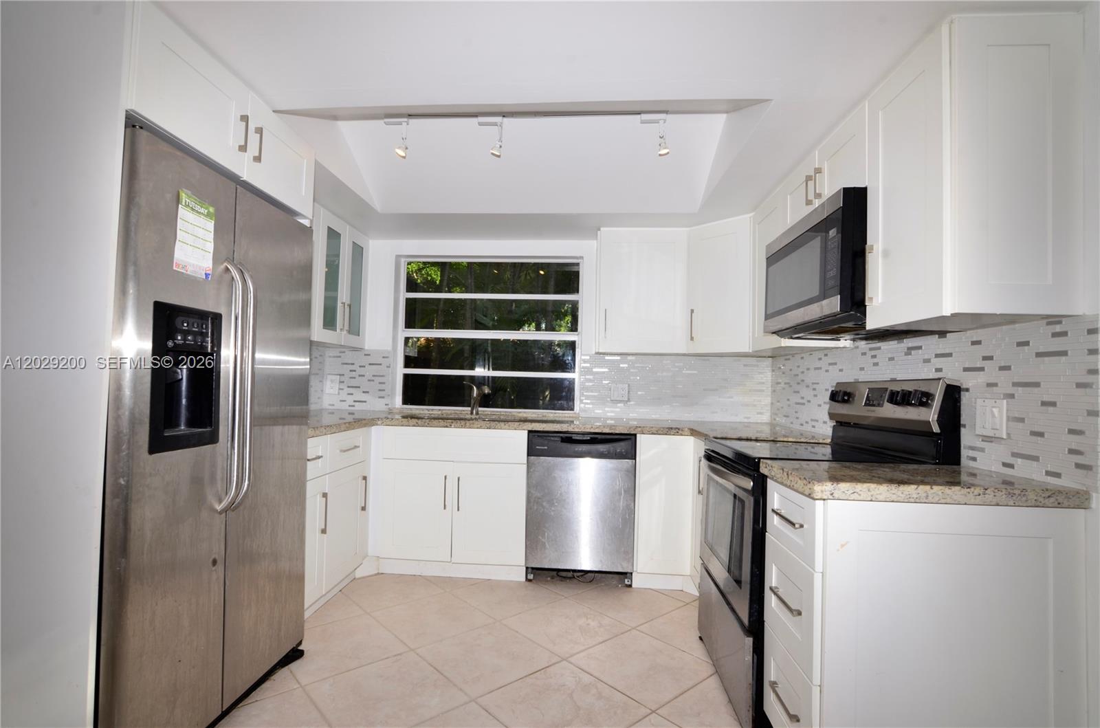 A kitchen features white cabinets, stainless steel appliances, granite countertops, and a tiled backsplash — 13224 SW 111th Ter # 3, Miami FL 33186, MIAMI, FL