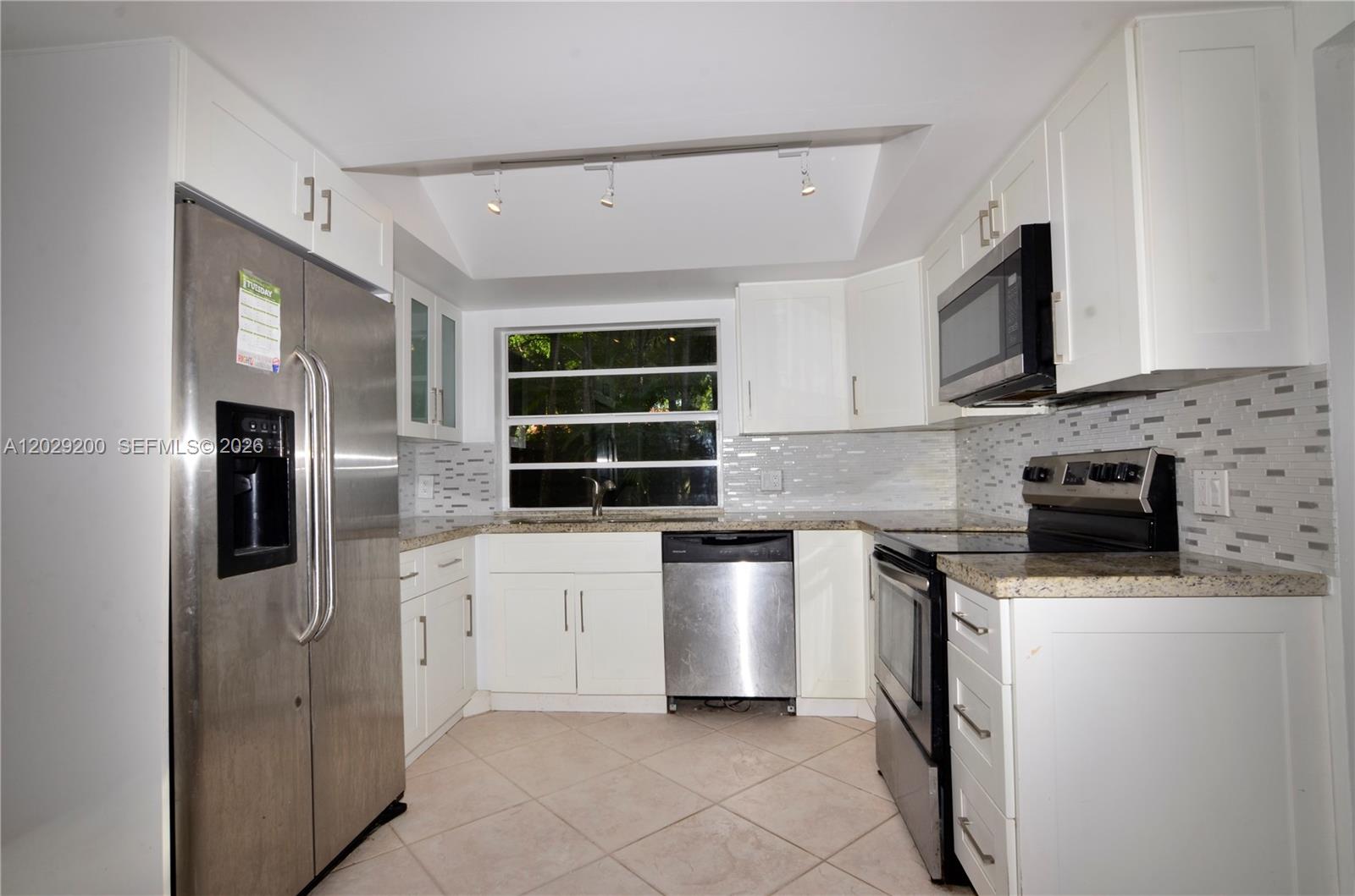 A kitchen with white cabinets, stainless steel appliances, granite countertops, and a tiled backsplash — 13224 SW 111th Ter # 3, Miami FL 33186, MIAMI, FL