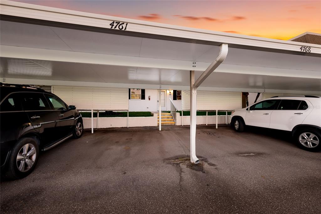 A covered parking area with two cars parked in front of a residential building — 4761 INDEPENDENCE DRIVE UNIT 4761, BRADENTON, FL