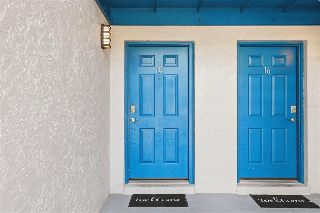 Two blue front doors labeled 10 and 16 are set in a white stucco wall — 10 N FAIRFAX AVENUE UNIT 10, WINTER SPRINGS, FL