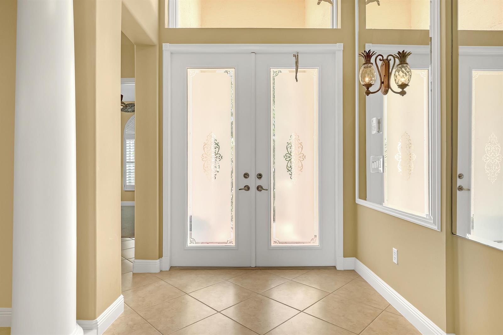 A bright entryway features double white doors with frosted glass panels and beige tile flooring — 9493 Via Elegante, Wellington FL 33411, WELLINGTON, FL