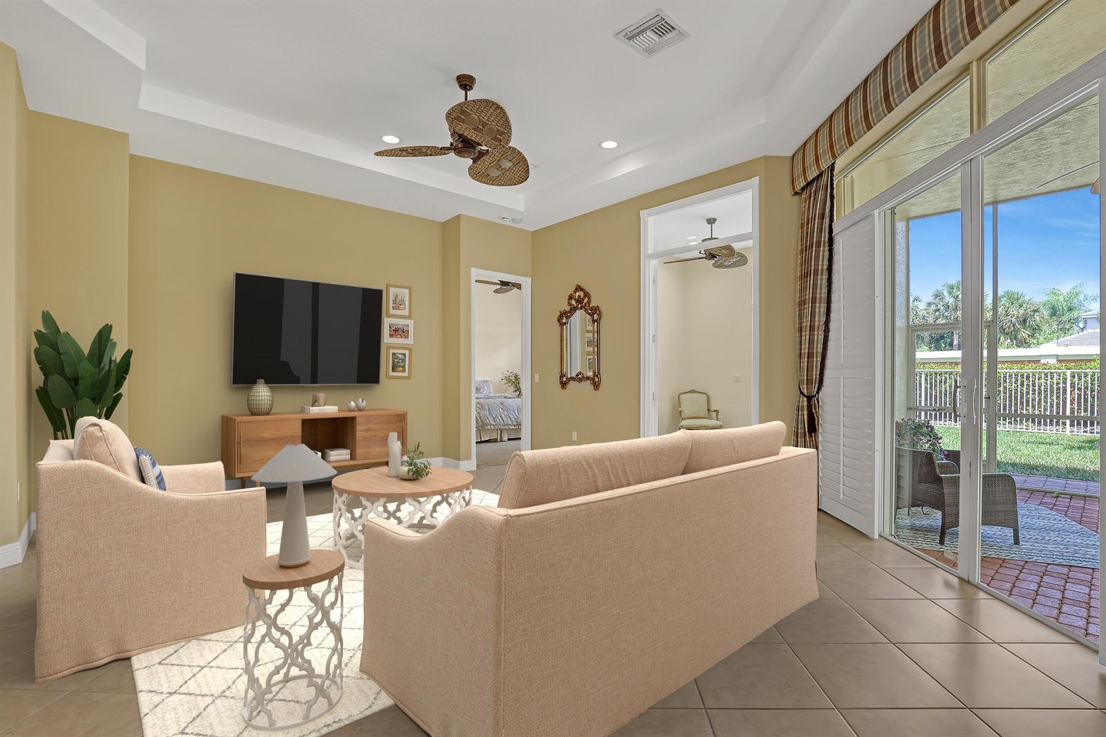 A living room with beige walls, a sofa, two armchairs, and sliding glass doors to a patio — 9493 Via Elegante, Wellington FL 33411, WELLINGTON, FL