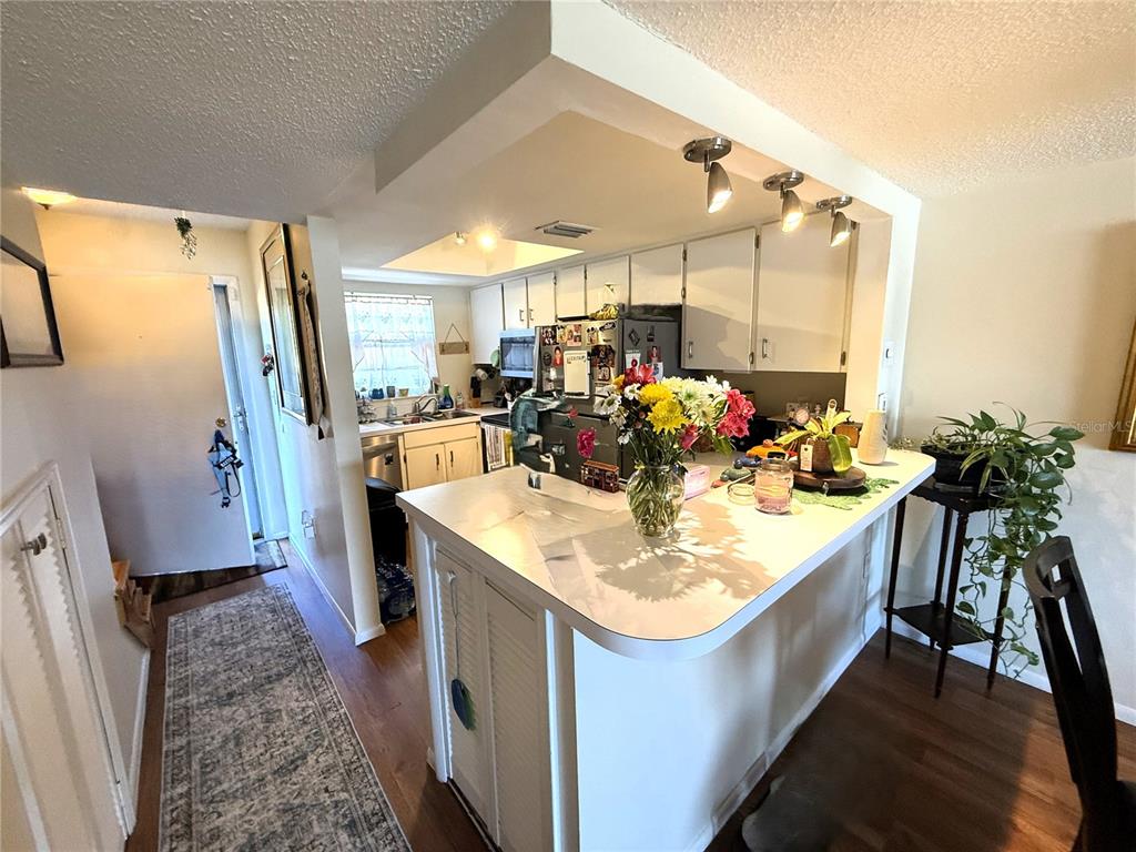 A kitchen with white cabinets, a breakfast bar, and a view of the entryway — 410 E ORLANDO AVENUE UNIT 19A, OCOEE, FL
