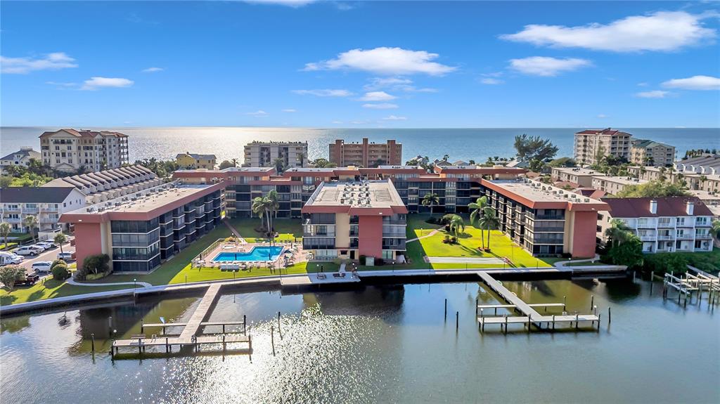 A kitchen with white cabinets, stainless steel appliances, and a blue tiled backsplash — 19701 GULF BOULEVARD UNIT 120, INDIAN SHORES, FL