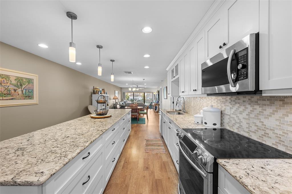 A kitchen features white cabinets, granite countertops, stainless steel appliances, and a long island — 4750 BRITTANY DRIVE S UNIT 126, ST PETERSBURG, FL
