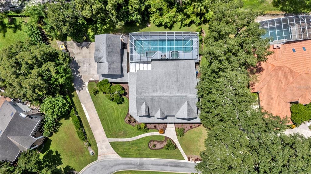 An aerial view shows a house with a screened-in pool and a long driveway — 1632 REGAL COVE COURT, KISSIMMEE, FL