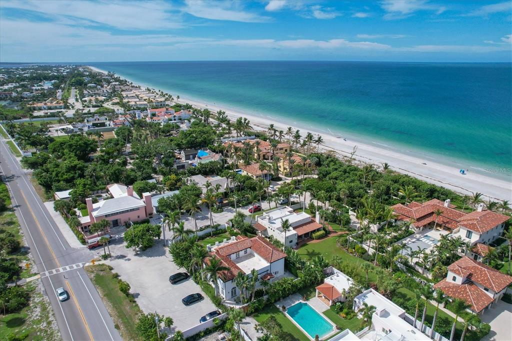 An aerial view of a coastal neighborhood with houses, lush trees, and a sandy beach — 1031 10TH STREET W, BOCA GRANDE, FL