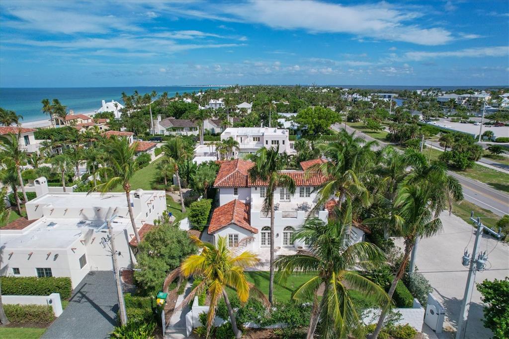 An aerial view of a white two-story house with a red tile roof near the ocean — 1031 10TH STREET W, BOCA GRANDE, FL