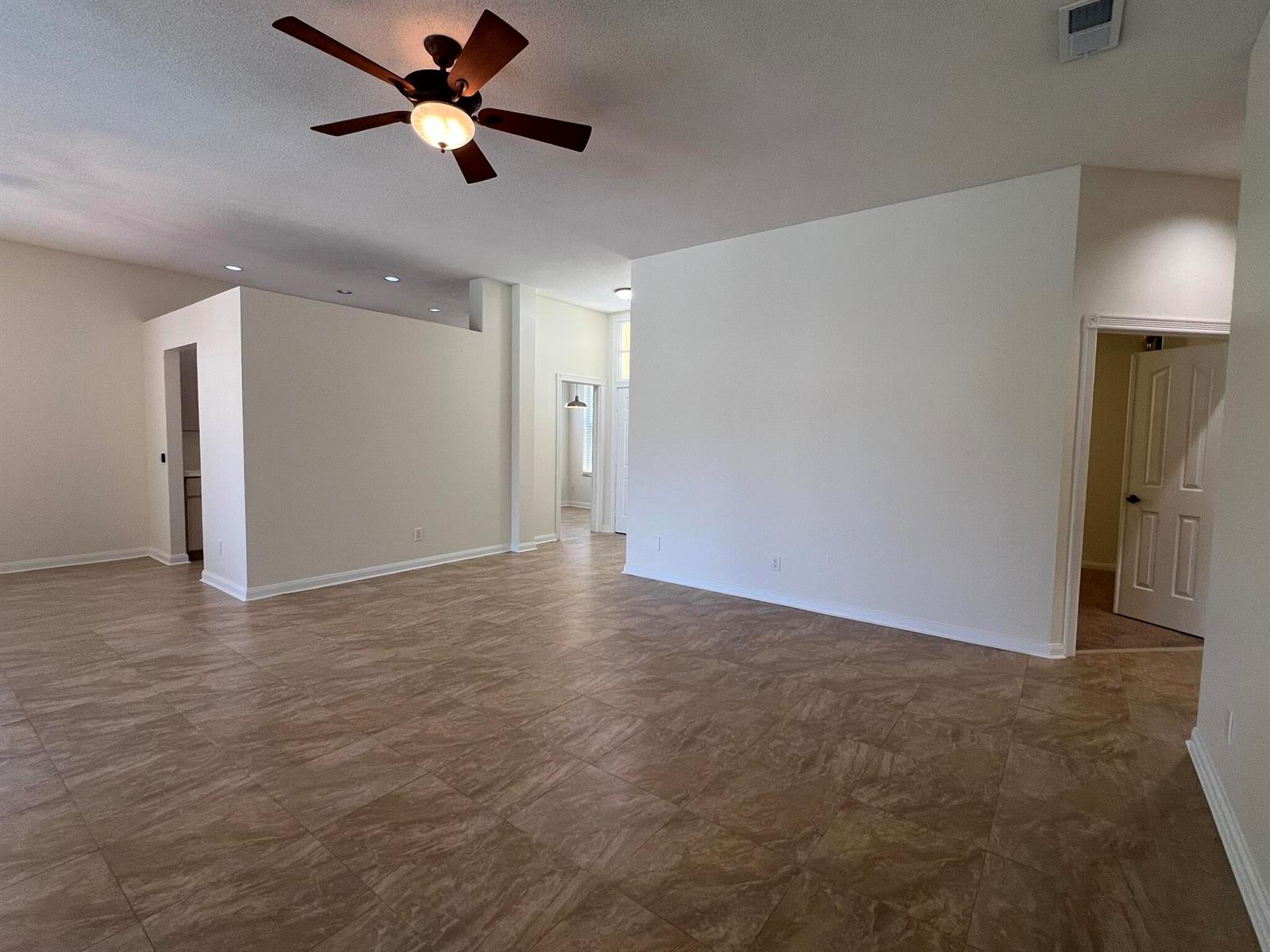 An open living area features tile flooring, a ceiling fan, and white walls — 244 Hampton Place, Jupiter FL 33458, JUPITER, FL