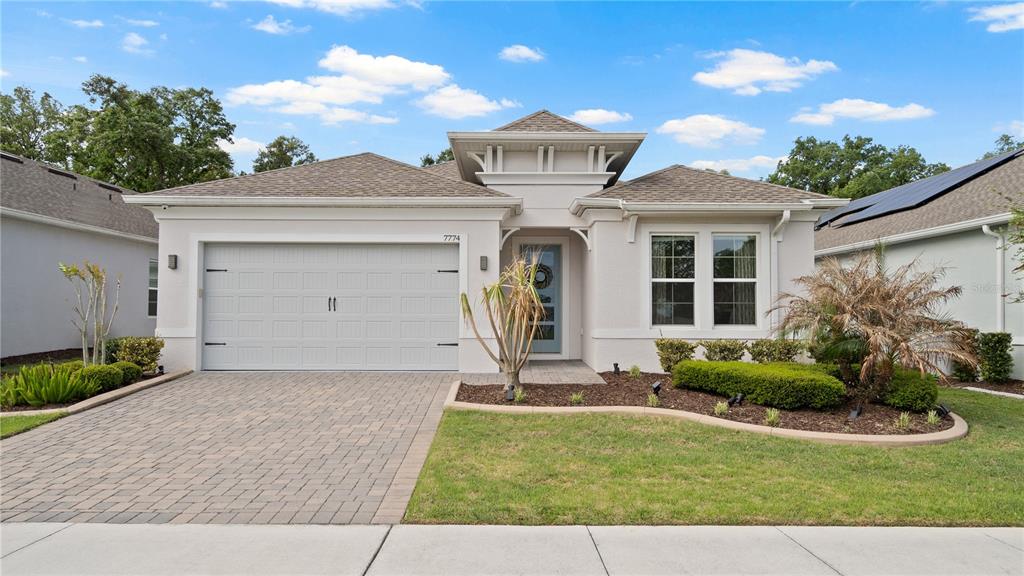 A single-story house with a light-colored stucco exterior, a two-car garage, and a paved driveway — 7774 FOUR SEASONS BOULEVARD, KISSIMMEE, FL