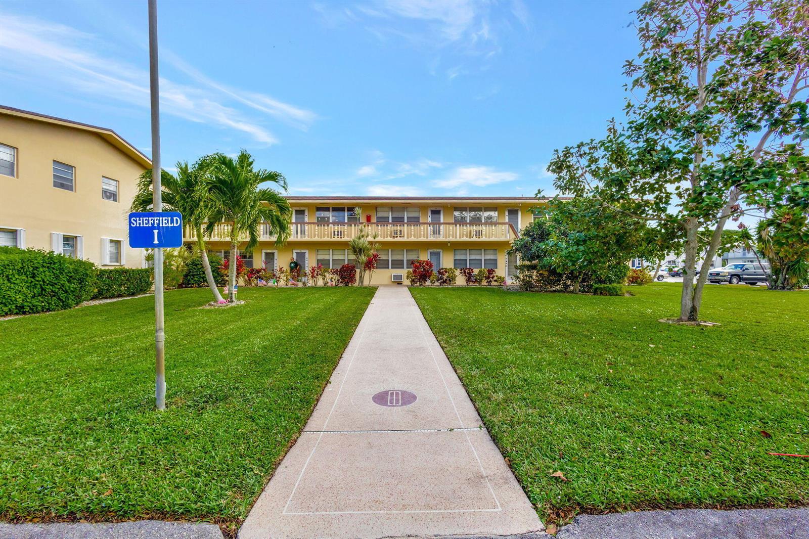 A two-story apartment building with a central walkway and a Sheffield I sign — 211 Sheffield I, West Palm Beach FL 33417, WEST PALM BEACH, FL