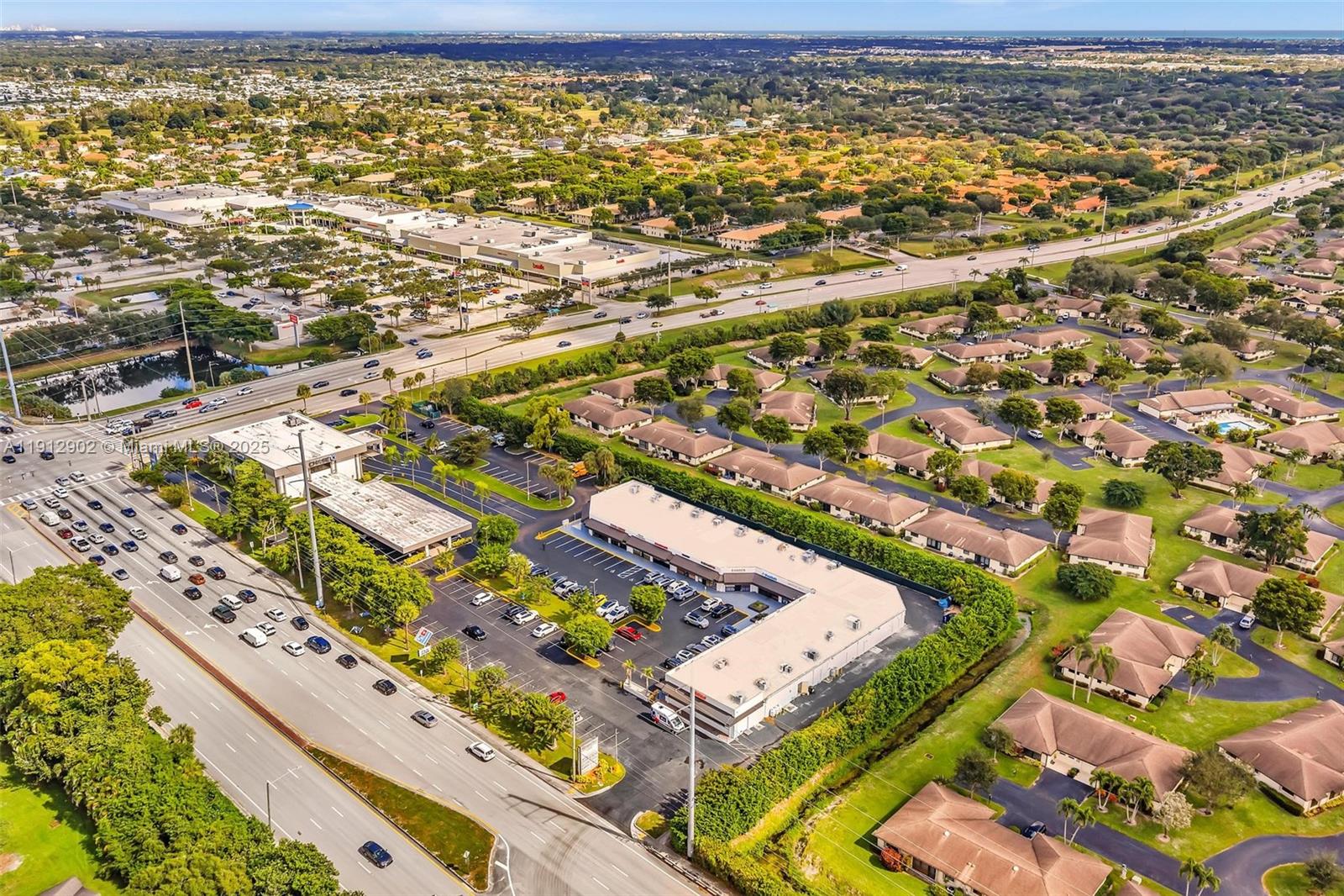 An aerial view shows a commercial strip mall surrounded by residential homes and roads — 10114 S Military Trl, Boynton Beach FL 33436, BOYNTON BEACH, FL