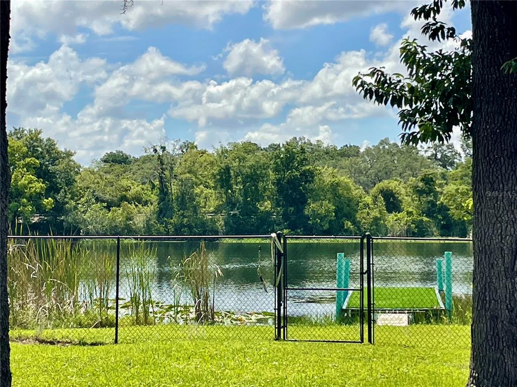 A single-story house with a front deck sits on a grassy lot with two trailers — 653 LAKE MOBILE DRIVE, ALTAMONTE SPRINGS, FL