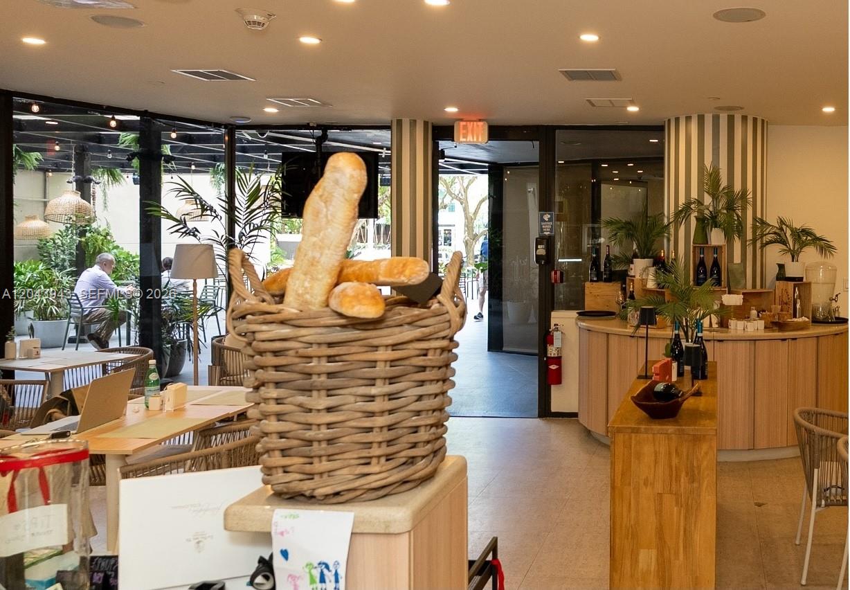 A wicker basket of baguettes sits on a counter in a bright restaurant interior — 848 NE Brickell Avenue, Miami FL 33131, MIAMI, FL