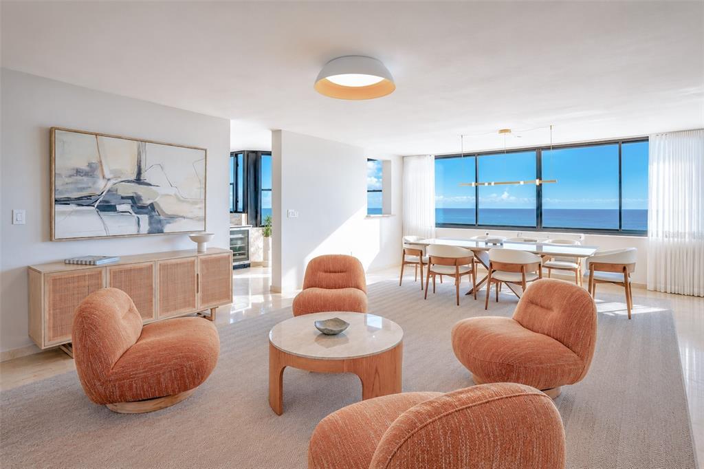A bright living and dining area features orange chairs, a round table, and ocean views — 1 C. MANUEL RODRIGUEZ SERRA UNIT 601-A, SAN JUAN, PR