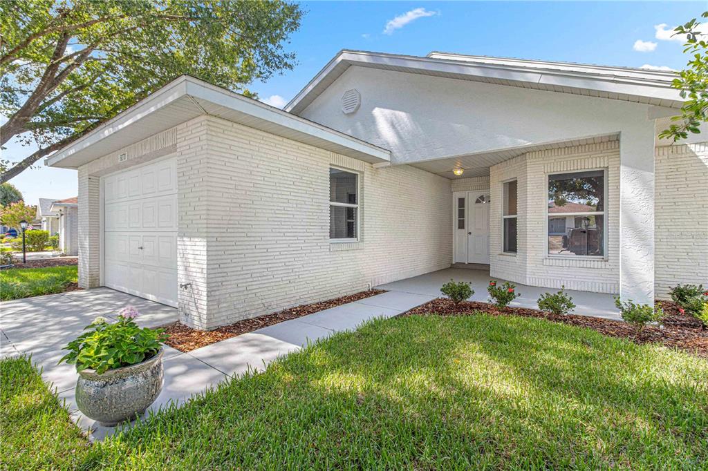 A single-story house with white brick siding, a garage, and a covered front entryway — 9270 SW 92ND PLACE ROAD, OCALA, FL