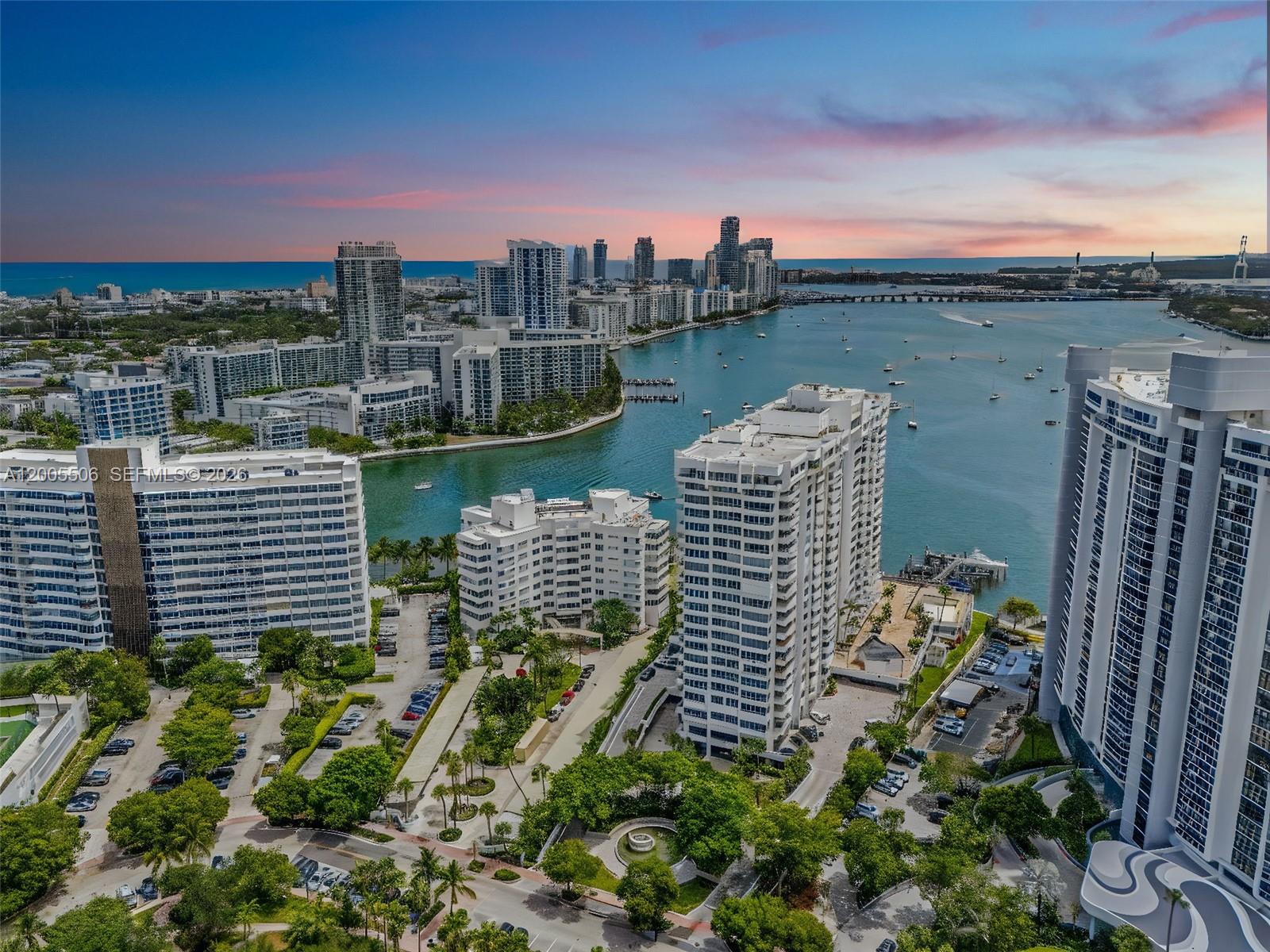 An aerial view shows several high-rise apartment buildings surrounded by trees and a waterway — 11 Island Ave # 411, Miami Beach FL 33139, MIAMI BEACH, FL