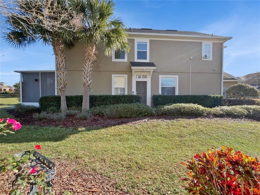 A two-story tan house features a front entrance, several windows, and palm trees in front — 4970 SW 45TH STREET, OCALA, FL
