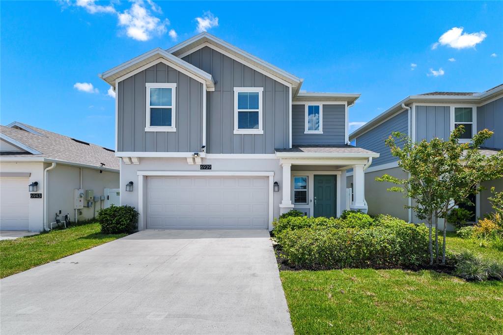A two-story house with a gray exterior, a two-car garage, and a front lawn — 6939 WILSON PASTURE AVENUE, GROVELAND, FL