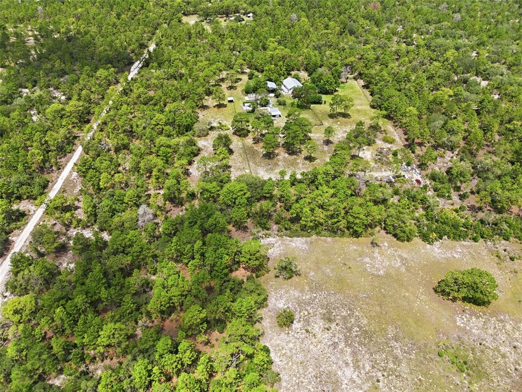 An aerial view shows a house and outbuildings surrounded by dense forest and open land — 0 N MATSONFORD AVENUE, DUNNELLON, FL