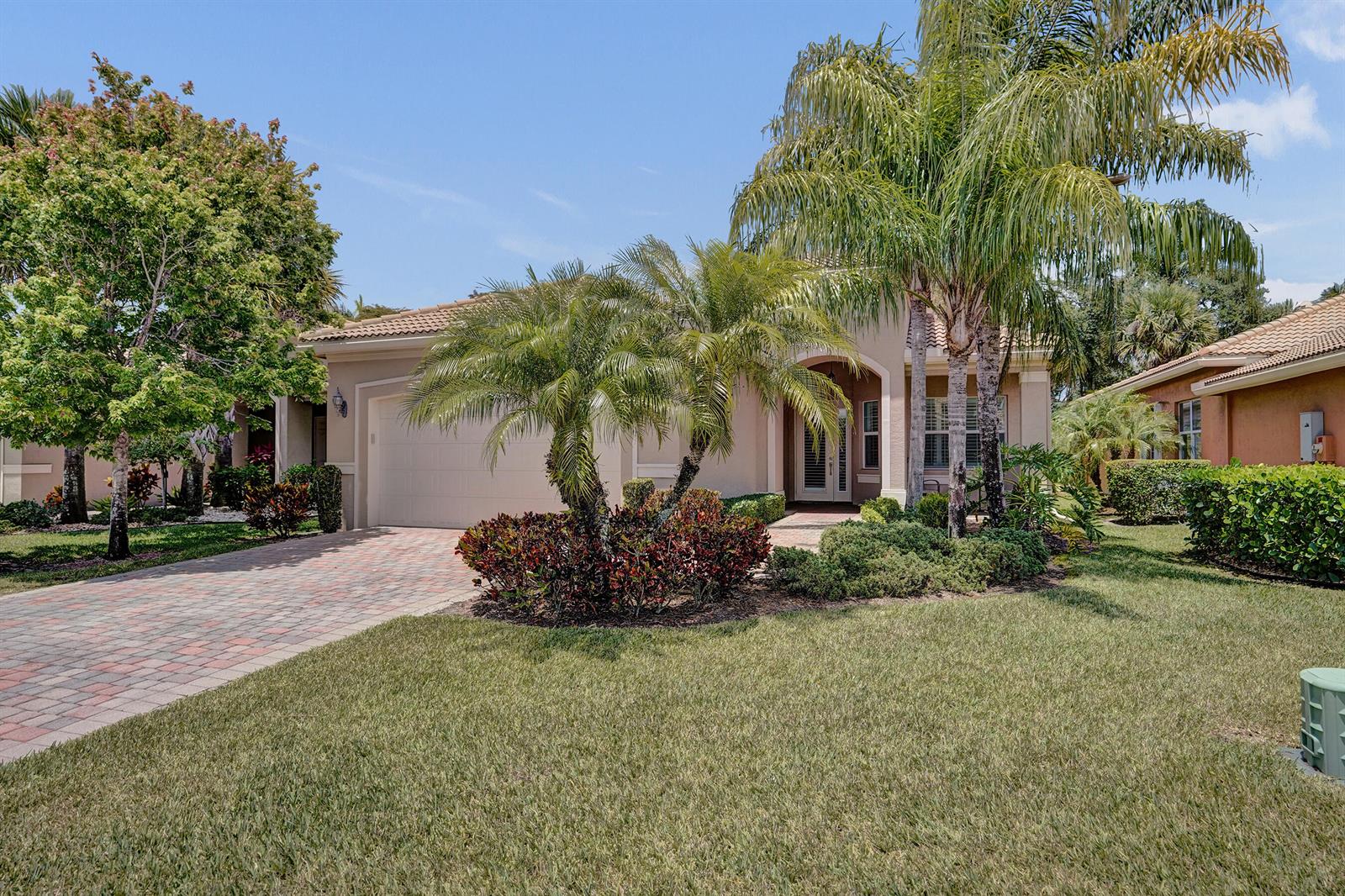 A single-story house with a paved driveway, palm trees, and a landscaped front yard — 8703 Carmel Mountain Way, Boynton Beach FL 33473, BOYNTON BEACH, FL