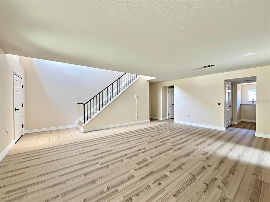 A staircase with light wood steps leads to an upper level beside a tiled hallway — 24301 SW 6TH PLACE, NEWBERRY, FL
