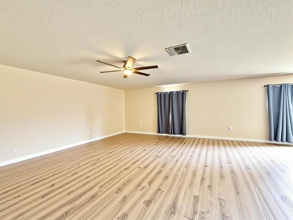 A kitchen with light wood cabinets, white countertops, a center island, and black appliances — 24301 SW 6TH PLACE, NEWBERRY, FL