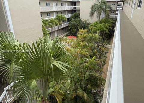 An elevated view of a courtyard with palm trees between two apartment building wings — 7815 Camino Real # i417, Miami FL 33143, MIAMI, FL