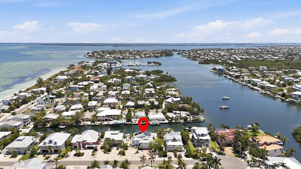 An aerial view shows a waterfront neighborhood with a red pin marking a specific house — 517 KUMQUAT DRIVE, ANNA MARIA, FL