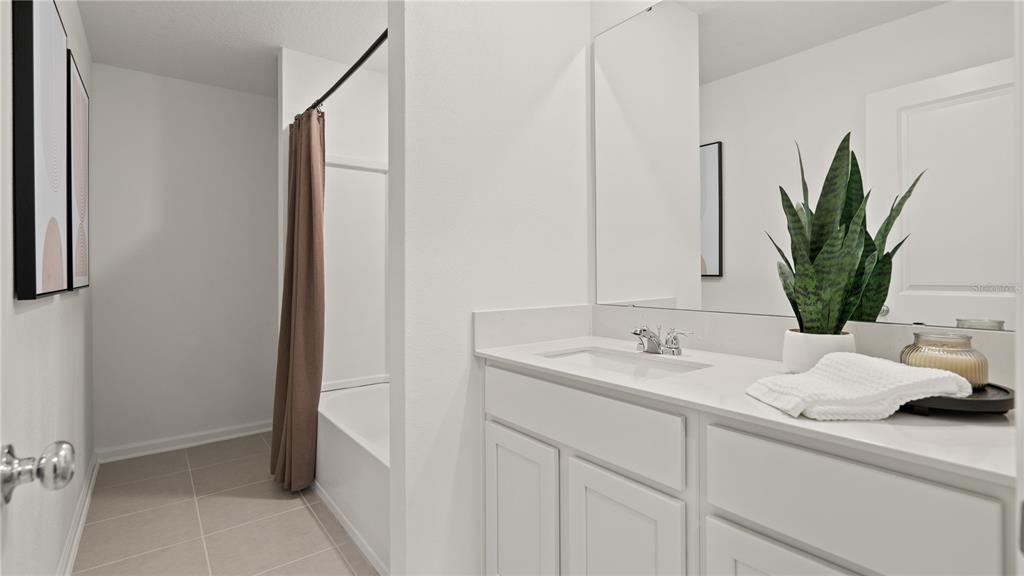 A bathroom features a white vanity, a single sink, and a shower-tub combination — 6225 BOTTICELLA BOULEVARD, WINTER HAVEN, FL