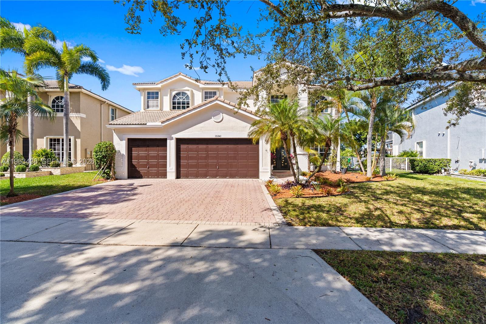 A two-story suburban house features a brick driveway, a three-car garage, and palm trees — 15341 SW 20th St, Miramar FL 33027, MIRAMAR, FL