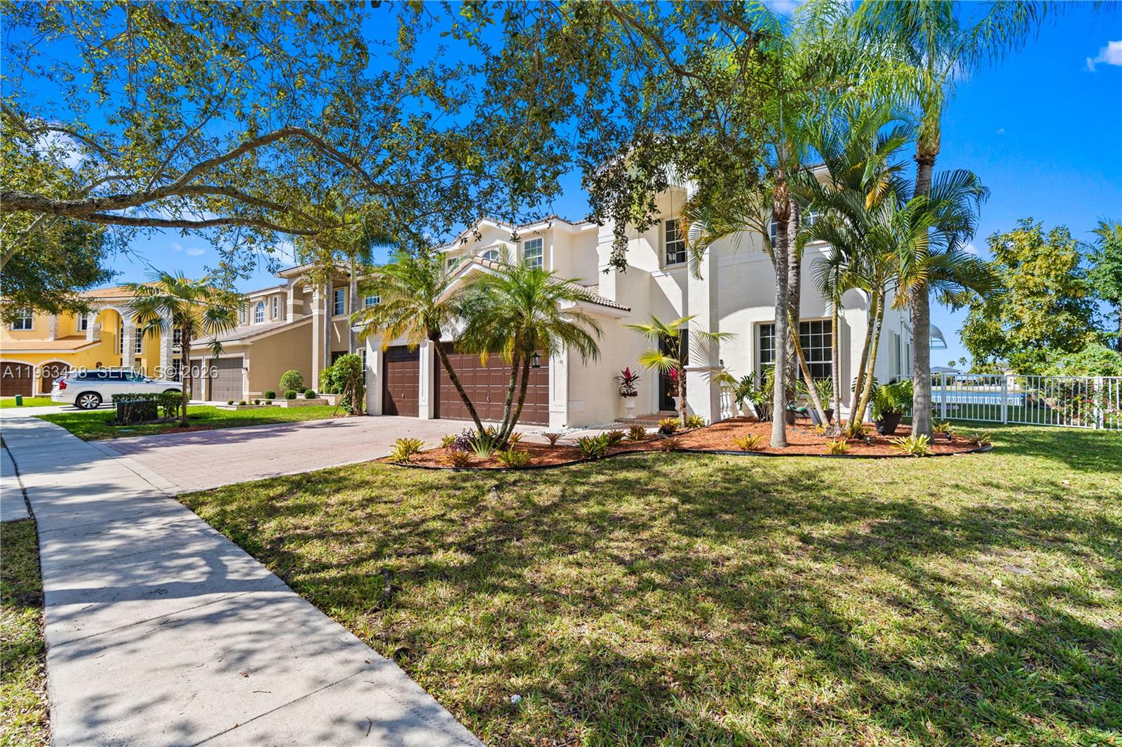 A two-story suburban house with a paved driveway, palm trees, and a grassy front yard — 15341 SW 20th St, Miramar FL 33027, MIRAMAR, FL