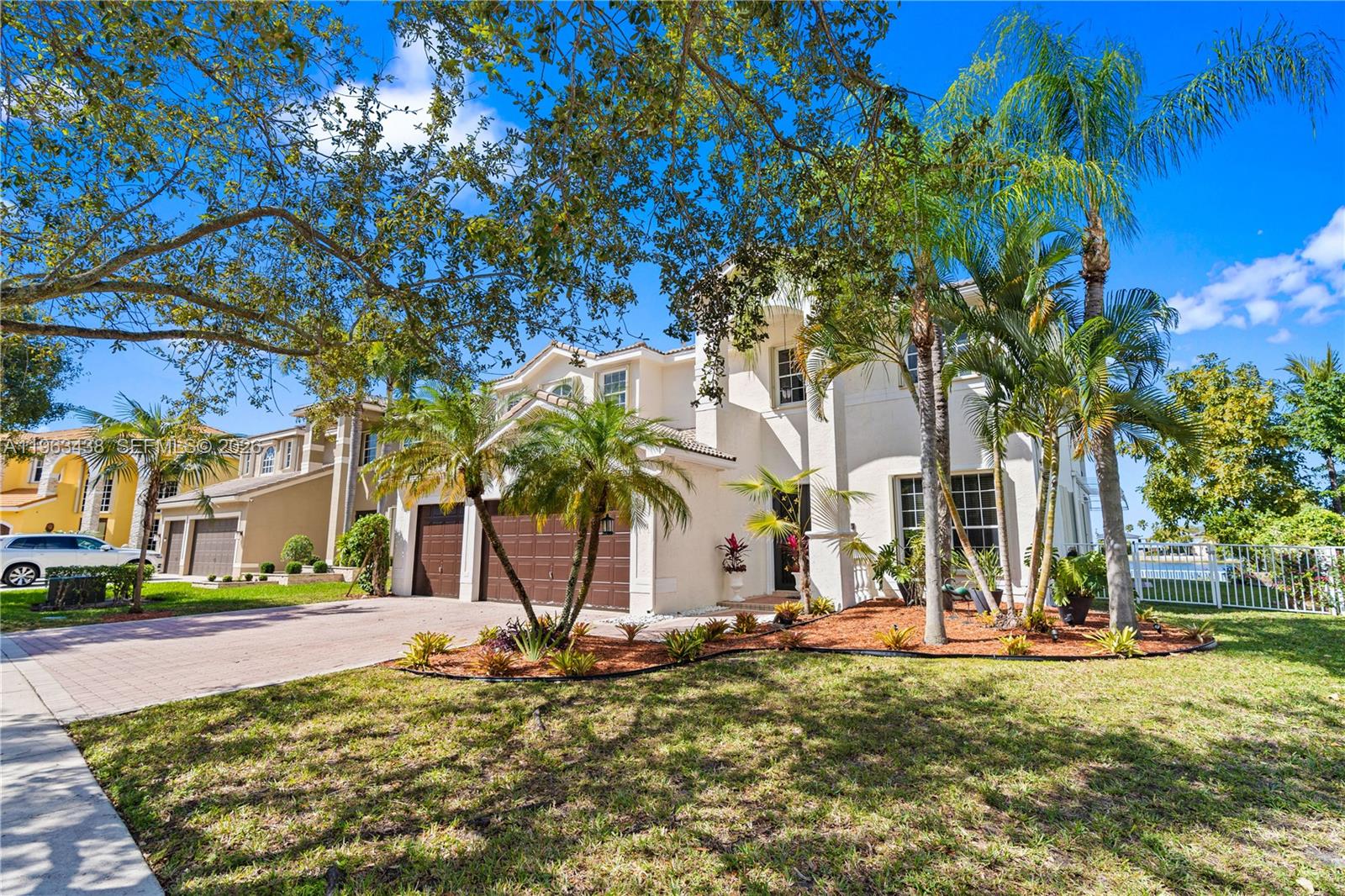 A two-story house with a beige exterior, a three-car garage, and palm trees in front — 15341 SW 20th St, Miramar FL 33027, MIRAMAR, FL