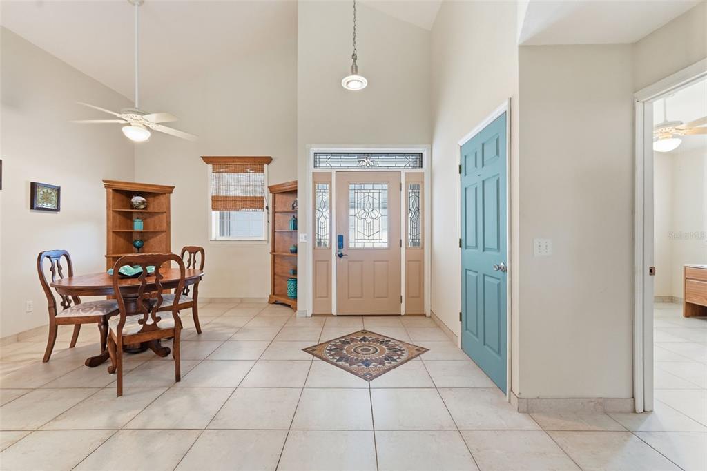 A dining area with tile flooring and a vaulted ceiling leads to a front entryway — 585 SELLARS DRIVE, LAKE ALFRED, FL
