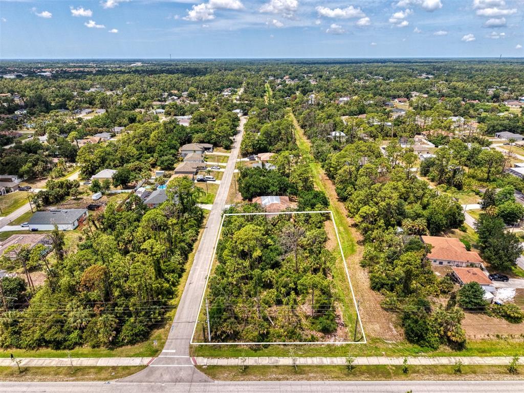 An aerial view shows a rectangular, tree-covered vacant lot outlined in white along a road — FONSICA AVENUE, NORTH PORT, FL