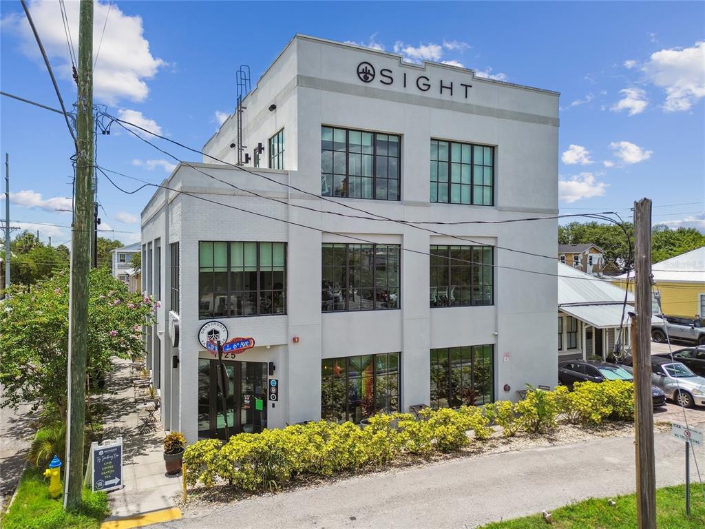 A three-story white commercial building with large windows and a flat roof under a blue sky — 1919 E 6TH AVENUE, TAMPA, FL
