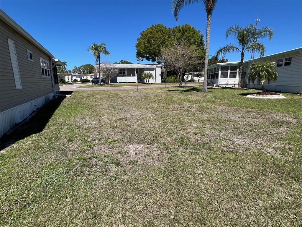 A grassy yard sits between two manufactured homes under a clear blue sky — 29250 US HIGHWAY 19 N UNIT 294, CLEARWATER, FL