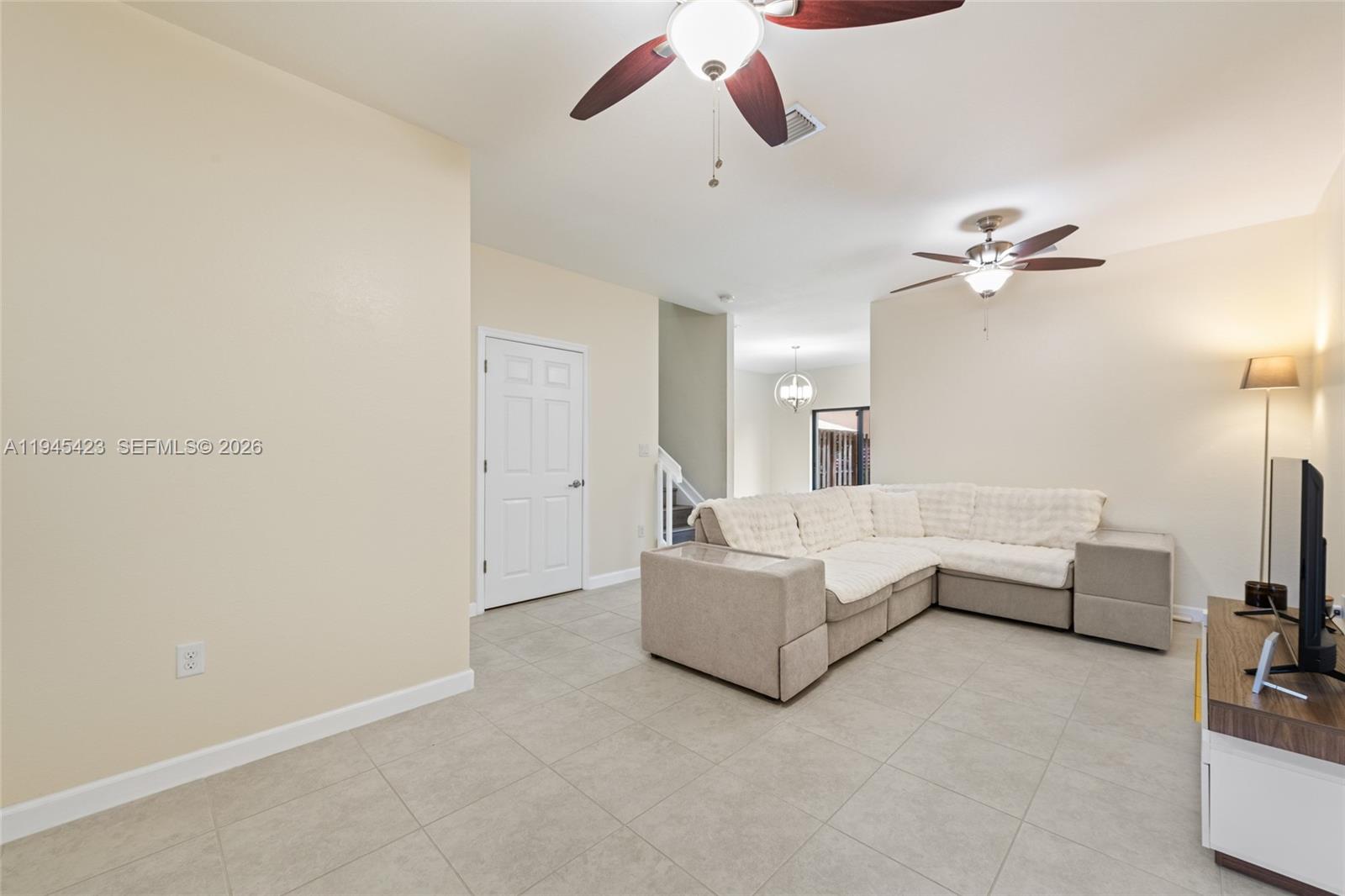 A living room features light tile flooring, a sectional sofa, and two ceiling fans — 3777 SE 3rd St, Homestead FL 33033, HOMESTEAD, FL