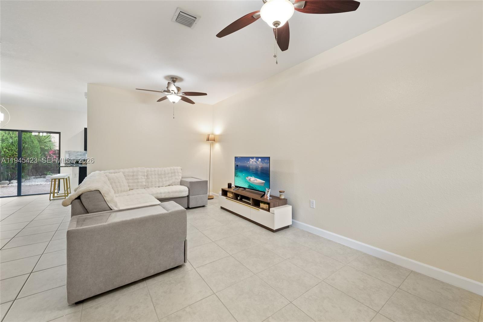 A living room features light tile flooring, a sectional sofa, and a television console — 3777 SE 3rd St, Homestead FL 33033, HOMESTEAD, FL