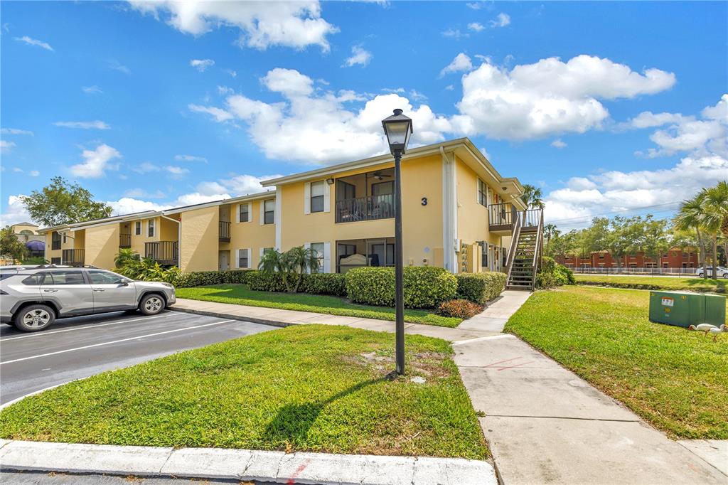 A two-story yellow apartment building with a parking lot and a sidewalk in front — 3001 58TH AVENUE S UNIT 315, ST PETERSBURG, FL