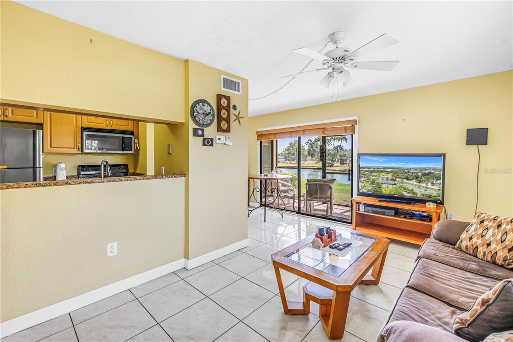 A living room with tile floors, a ceiling fan, and a sliding door to a patio — 3001 58TH AVENUE S UNIT 315, ST PETERSBURG, FL