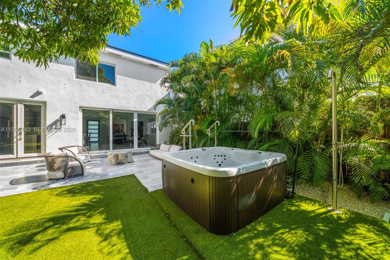 A backyard patio features a hot tub, artificial turf, and an outdoor shower — 3166 Royal Palm Ave, Miami Beach FL 33140, MIAMI BEACH, FL
