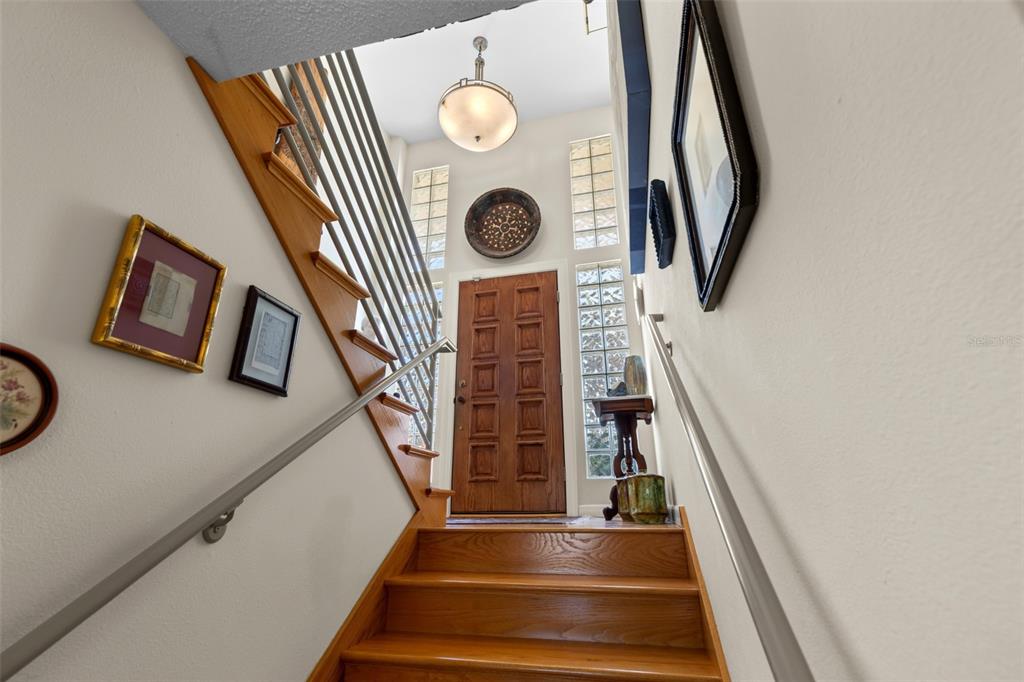 A wooden staircase leads up to a front door with glass block windows — 609 42ND STREET COURT W, PALMETTO, FL